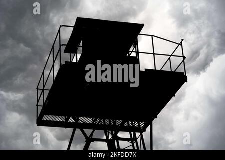 Dunkle Silhouette der Metallstruktur des Wachturms, Wolken im Hintergrund Stockfoto