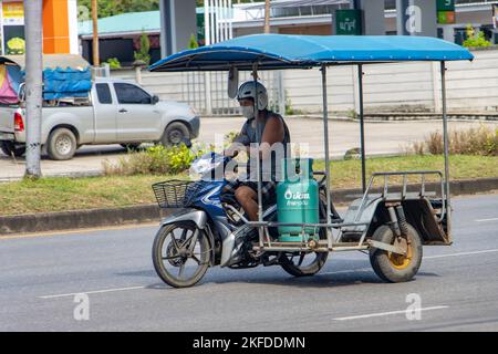 RATCHABURI, THAILAND, NOVEMBER 16 2022, Ein Mann trägt eine Gasflasche auf einem Motorrad mit Beiwagen Stockfoto