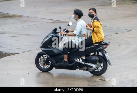 SAMUT PRAKAN, THAILAND, SEP 26 2022, das Paar fährt auf dem Motorrad auf der nassen Straße. Stockfoto