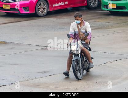 SAMUT PRAKAN, THAILAND, SEP 26 2022, Ein Mann mit Gesichtsmaske fährt ein Motorrad Stockfoto