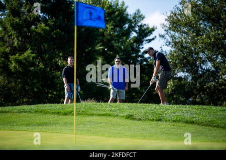 Von rechts schlägt Maj. Daniel Norton, der für Standardisierung und Evaluierung der 436. Operations Group zuständige Offizier, einen Golfball auf das Grün, während seine Teamkollegen, Col. Rusty Gohn, Vizekommandant des 436. Airlift Wing, Und Maj. Brad Wilson, 436. AW Executive, beobachten während des Bluesuiters Golf Tournament auf Jonathan's Landing Golf Course in Magnolia, Delaware, 9. September 2022. Bluesuiters ist ein halbjährliches Golfturnier, das das Team Dover Airmen mit lokalen Staats- und Geschäftsführern verbinden soll. Stockfoto