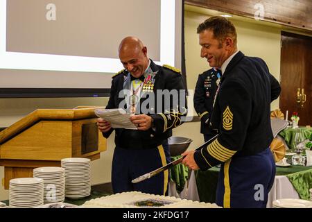 Oberst Andy Kiser, links, Kommandant der 2. Stryker Brigade Combat Team, 4. Infanterie Division, liest ein Skript, während Command Sgt. Maj. Michael Eiermann, rechts, Kommandofeldwebel Major von 2. SBCT, 4. Inf. Div., schneidet einen Kuchen während eines Essens in Ft. Carson, Colorado, September 9. Die Brigade veranstaltete das Abendessen, um seine Vergangenheit zu feiern, ein zusammengehörigeres Team aufzubauen und eine soziale Atmosphäre für Kameradschaft und Spaß zu schaffen. Foto der US-Armee von Maj. Jason Elmore. Stockfoto