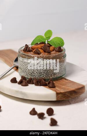 chia Pudding mit Schokolade und Mandeln auf weißem Tisch Stockfoto