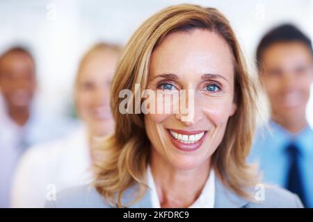 Reife weibliche Führungskraft mit Team im Seminar. Nahaufnahme einer reifen weiblichen Führungskraft, die mit dem Team im Seminar lächelt. Stockfoto