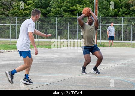 Luftstreitkräfte Adedapo Ajayi, ein Airman mit dem 181. Intelligence Wing, schießt einen drei-Punkte-Schuss während eines drei-zu-drei-Turniers nach dem Ende des Diensttages auf der Hulman Field Air National Guard Base, Ind., 10. September 2022. Das Turnier, das 2018 begann, soll Geld für wohltätige Zwecke sammeln und gleichzeitig Kameradschaft fördern. Stockfoto