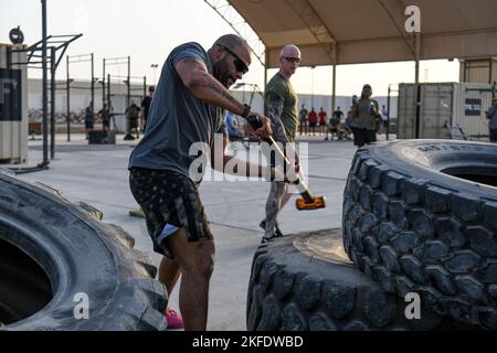 Kapitän Damon Gandy, der Einsatzoffizier der 380. Expeditionary Security Forces Squadron, versucht während des „Defender Relay“-Rennens in der Schlacht der Badges am 10. September 2022 auf dem Luftwaffenstützpunkt Al Dhafra, Vereinigte Arabische Emirate, einen Reifen zu umschlagen. Der Defender Relay bat ein Team von drei Personen, einen M4 Karabiner zu zerlegen, einen Reifen mit einem Vorschlaghammer zu bewegen, einen 225 Pfund schweren 100-Meter-Schlitten zu schieben, Sandsäcke zu werfen und einen M4 Karabiner wieder zusammenzubauen, wobei die Komponenten eines improvisierten Sprengstoffgerätes in Erinnerung bleiben sollten. Viele Battle of the Badges-Wettbewerbe werden bundesweit als jährliches Rennen ausgetragen Stockfoto