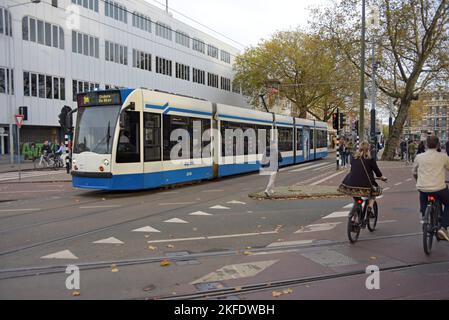Straßenbahn und Radfahrer auf den Straßen von Amsterdam, Niederlande Stockfoto