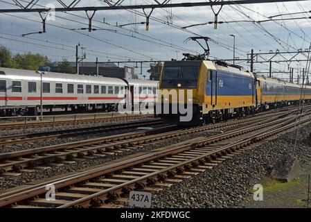 Die Deutsche Bahn in Amsterdam bereitet sich auf die Rückfahrt nach Deutschland vor, wobei eine elektrische Klasse-186-Intercity-Lokomotive vorbeifährt. Stockfoto