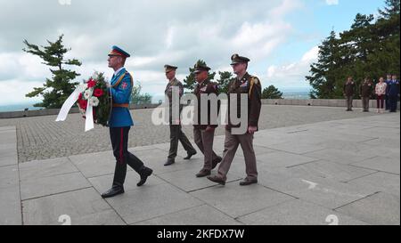 Ein Mitglied der serbischen Streitkräfte trägt einen Kranz und führt eine Prozession, zu der der General General John C. Harris Jr. (zweiter von rechts), Ohio Adjutant General, zum Denkmal des unbekannten Helden, das sich auf dem Berg Avala, 10. September 2022, in der Nähe von Belgrad, Serbien, befindet. Die Kranzniederlegung war Teil des offiziellen Besuchs einer Delegation der Ohio National Guard anlässlich der 16-jährigen Partnerschaft zwischen Ohio und Serbien. (Foto von Stephanie Beougher, Ohio National Guard Public Affairs) Stockfoto