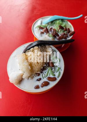 Malaysias traditionelles, süßes Dessert-Cendol, serviert in einer Schüssel mit Glutinreis, Kokosmilch und roten Bohnen. Stockfoto