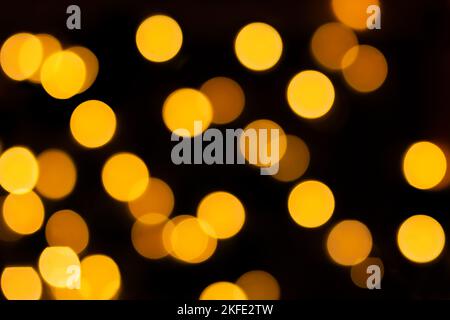 Gelbes, unscharfes Bokeh auf schwarzem, isolierten Hintergrund. Defokussed Lichter. Für Overlay-Design. Neujahr, Weihnachten, Urlaub Stockfoto