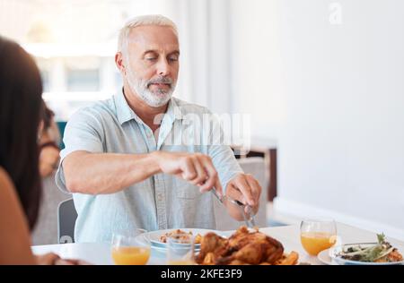 Familie, truthahn und älterer Mann schneiden Fleisch zum Brunch-Buffet, zur Wiedersehensfeier oder zum Festmahl für hungrige Menschen. Ältere Person, die Huhn schneidet Stockfoto