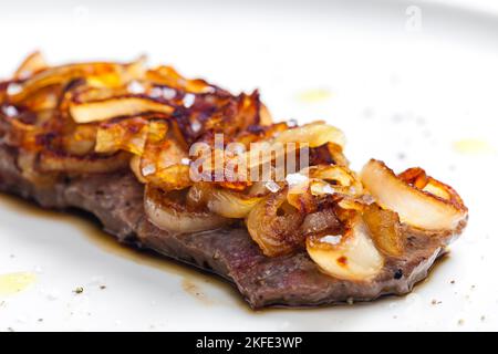 Steak mit karamellisierten Zwiebeln bedeckt Stockfoto