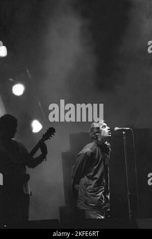 OASIS, ERSTE GLASTONBURY-HEADLINE, 1995: Liam Gallagher und Bonehead (Paul Arthurs) von Oasis treten während des Encore auf, als die Manchester-Band die Main Stage auf dem Höhepunkt ihres Ruhmes auf dem Glastonbury Festival, Pilton Farm, Somerset, England, am 24. Juni 1995 als Headliner der Main Stage auftritt. 1995 feierte das Festival sein 25-jähriges Bestehen. In diesem Jahr gab es keine Pyramidenphase, da sie abgebrannt war. Foto: ROB WATKINS Stockfoto