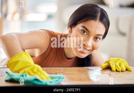 Lächeln, Reinigung und Stoff mit Porträt von Frau und Tisch für Hygiene, Bakterien und Staub. Housekeeping, Reinigung und Waschen mit Mädchen zu Hause Stockfoto