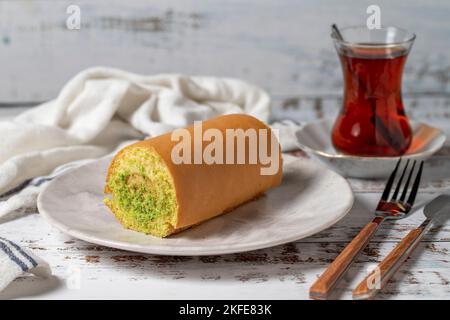 Roll Cake mit Banane auf weißem Holzhintergrund. Patisserie Desserts Stockfoto