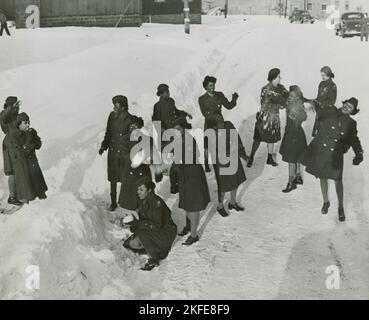 Afroamerikanische Mitglieder des Women's Army Corps, die im Schnee stehen und sich gegenseitig mit Schneebällen beworfen haben, Camp Shanks, New York, 1946. Stockfoto