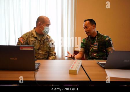 Capt. Aab Abdul Wahab, TNI, und der Major der US-Armee, Joshua Mayer, besprechen die Operationen in der Übungskontrollgruppe für Gema Bhakti 22, 12. September 2022, Jakarta Indonesien. Die GEMA Bhakti 22 ist eine Veranstaltung des USINDOPACOM Joint Exercise Program, bei der die US-Streitkräfte in Zusammenarbeit mit den TNI-Streitkräften zusammenarbeiten, um die Interoperabilität zu erhöhen und die regionale Stabilität und Sicherheit durch bilaterale und multilaterale Partnerschaften zu verbessern. (FOTO DER US Air Force von Master Sgt. Andrew Jackson) Stockfoto