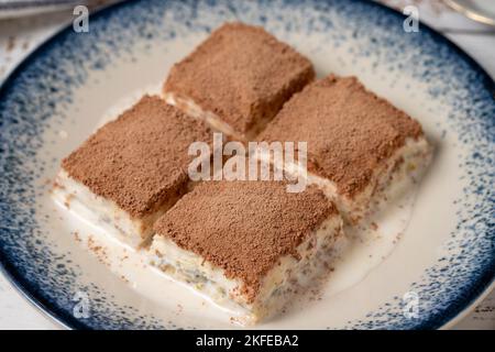 Kaltes Baklava auf weißem Holzhintergrund. Baklava mit Milch und Pistazie. Köstlichkeiten der mediterranen Küche. Nahaufnahme Stockfoto