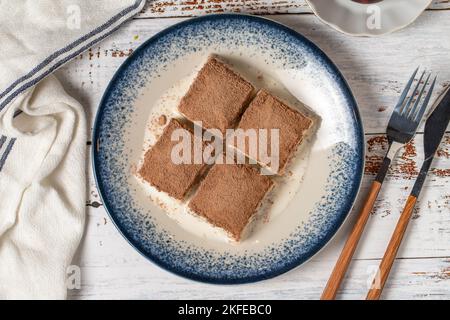 Kaltes Baklava auf weißem Holzhintergrund. Baklava mit Milch und Pistazie. Köstlichkeiten der mediterranen Küche. Draufsicht Stockfoto