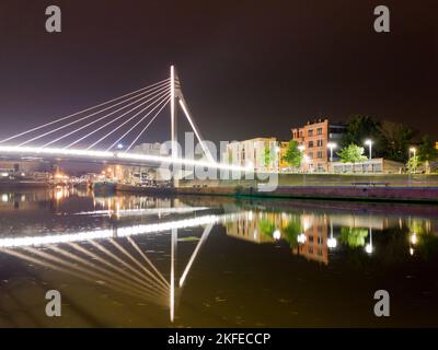 Stadtbild mit moderner concrette illumanite Brücke bei Nacht und Boote und Autos im Hintergrund Stockfoto