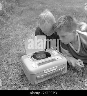 Wie ein kombinierter tragbarer Radio- und Plattenspieler im Jahr 1960s aussah. Ein Grammophonspieler, wie es zu dieser Zeit aussah. Dieses Modell war batteriebetrieben und konnte Singles, 7 Zoll 45 U/min Vinyl-Schallplatten spielen. Sie können das Radio auch über die Radiofunktion hören, indem Sie die Regler auf die Frequenz und den Sender drehen, den Sie hören möchten. Ein praktischer Deckel ist geöffnet zu sehen und wenn Sie das Grammophon nicht benutzen, haben Sie es geschlossen. Schweden 1960 Conard Ref. 4264 Stockfoto