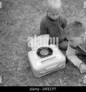 Wie ein kombinierter tragbarer Radio- und Plattenspieler im Jahr 1960s aussah. Ein Grammophonspieler, wie es zu dieser Zeit aussah. Dieses Modell war batteriebetrieben und konnte Singles, 7 Zoll 45 U/min Vinyl-Schallplatten spielen. Sie können das Radio auch über die Radiofunktion hören, indem Sie die Regler auf die Frequenz und den Sender drehen, den Sie hören möchten. Ein praktischer Deckel ist geöffnet zu sehen und wenn Sie das Grammophon nicht benutzen, haben Sie es geschlossen. Schweden 1960 Conard Ref. 4264 Stockfoto