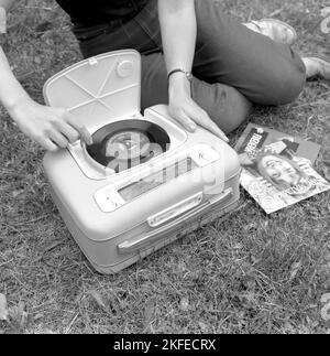 Wie ein kombinierter tragbarer Radio- und Plattenspieler im Jahr 1960s aussah. Ein Grammophonspieler, wie es zu dieser Zeit aussah. Dieses Modell war batteriebetrieben und konnte Singles, 7 Zoll 45 U/min Vinyl-Schallplatten spielen. Sie können das Radio auch über die Radiofunktion hören, indem Sie die Regler auf die Frequenz und den Sender drehen, den Sie hören möchten. Ein praktischer Deckel ist geöffnet zu sehen und wenn Sie das Grammophon nicht benutzen, haben Sie es geschlossen. Schweden 1960 Conard Ref. 4264 Stockfoto