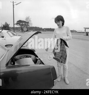 Einkaufen in der 1960s. Eine Dame hat ihr Auto im Supermarkt geparkt und nimmt ihren Warenkorb auf dem Parkplatz heraus. Ein Neuheitsartikel, der ursprünglich aus den USA kam. Schweden april 14 1966 Conard Ref. 5236 Stockfoto