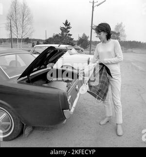 Einkaufen in der 1960s. Eine Dame hat ihr Auto im Supermarkt geparkt und nimmt ihren Warenkorb auf dem Parkplatz heraus. Ein Neuheitsartikel, der ursprünglich aus den USA kam. Schweden april 14 1966 Conard Ref. 5236 Stockfoto