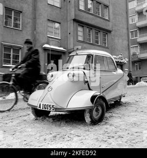 Winterfahren in der 1950s. Ein junger Mann fährt mit dem deutschen Kleinwagen Messerschmitt kr200. Ein dreirädrigen Kleinwagen mit genügend Platz für zwei Erwachsene und ein Kind im Auto. Das Auto wurde zwischen 1955 und 1964 hergestellt. Schweden 1956 Stockfoto