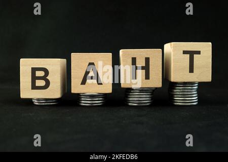 Thailands Konzept für wirtschaftliches und finanzielles Wachstum und Erholung. Steigender Münzstapel auf dunkelschwarzem Hintergrund mit Wort Thai Baht. Stockfoto