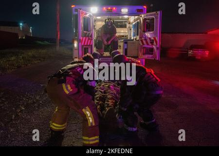 Feuerwehrleute, die den 51. Mitarbeitern des Teams für Bauingenieure und Einsatzkräfte zugewiesen wurden, beginnen, während eines Brandszenarios auf dem Luftwaffenstützpunkt Osan, Republik Korea, am 12. September 2022, ein simuliertes Opfer in einen Krankenwagen zu heben, um eine Flügelausbildung zu unterstützen. Die simulierten Verletzungen beurteilten die Fähigkeit von Airmen, Rettungsaktionen in einer feindlichen Umgebung zu unterstützen und auszuführen. Stockfoto