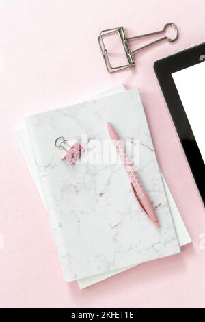 Femininer, flacher Schreibtisch mit Büroarbeitsplatz-Szene mit weißen und silbernen Papeterie-Accessoires, einschließlich Tastatur und Maus mit einem Modell eines Stockfoto