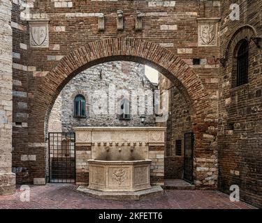 Der Brunnen wurde 1928 vom Architekten Pietro Angelini im mittelalterlichen Stil erbaut und befindet sich in der Via Maestà delle Volte unter einem Bogen aus dem 15.. Jahrhundert. Perugia Stockfoto