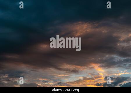 Dramatische oder filmische Wolken bei Sonnenaufgang. Wolkenlandschaft am Morgen. Konzeptfoto mit dunklen Wolken oder Sturm. Stockfoto