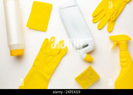 Plastikflaschen mit Reinigungsmittel, Schwamm und Handschuh auf weißem Hintergrund. Stockfoto