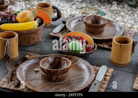 Nahaufnahme auf einem exotischen Tisch. Mehrere Früchte sind sichtbar. Die Gerichte sind aus Holz Stockfoto