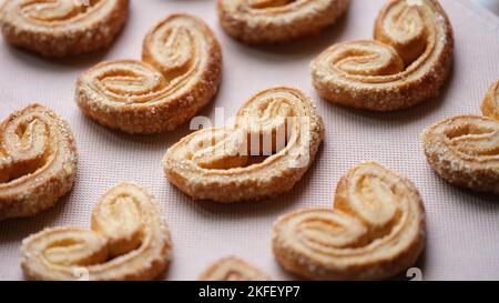 Viele herzförmige Plätzchen werden auf Tischdecken gelegt. Stockfoto