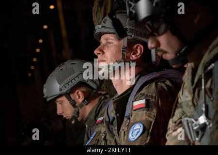 Die Mitglieder der US-Luftwaffe und der polnischen Landstreitkräfte warten darauf, einen Luftabwurf der statischen Linie von einem C-130J Super Hercules Flugzeug durchzuführen, das im Rahmen des Flugabwehrrotations-Trainings 22-4 (ADR 22-4) über der Bleidowska-Fallzone, Polen, dem 13. September 2022, dem Luftwaffengeschwader 37., der Ramstein Air Base, Deutschland, zugewiesen wurde. Die Teilnahme an Schulungsveranstaltungen wie ADR 22-4 verbessert die beruflichen Beziehungen und verbessert die Gesamtkoordination mit Verbündeten und Partnermilitärs. Stockfoto