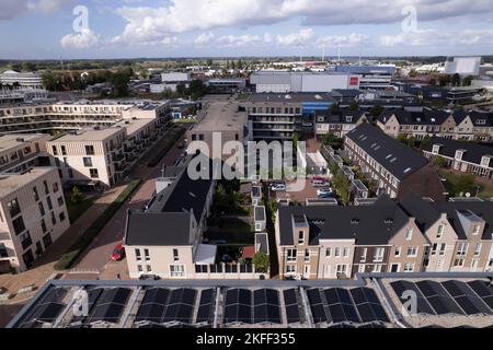 Sonnenkollektoren auf dem Apartmentkomplex in Noorderhaven von oben gesehen. Luftbild der modernen energieneutralen Bauarchitektur. Stockfoto