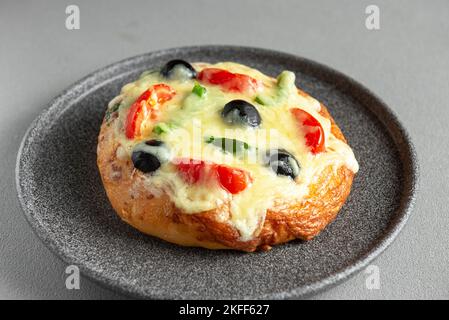 Hausgemachte Pizza mit Käse, Oliven, Tomaten und grünem Paprika. Draufsicht auf grauem Hintergrund Stockfoto