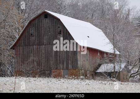 Eine alte, schneebedeckte Holzscheune im Winter Stockfoto