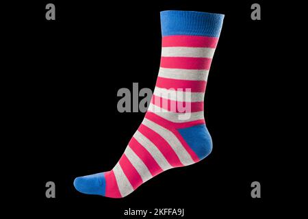 Eine volumetrische Socke mit verschiedenen, auf schwarzem Hintergrund isolierten Linien. Bunte volumetrische Socken. Farbige Socken am Bein isoliert auf schwarzem Hintergrund Stockfoto