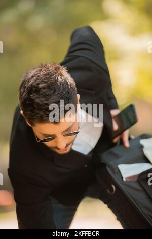 Nahaufnahme eines Geschäftsmannes, der versucht, etwas zu holen Stockfoto
