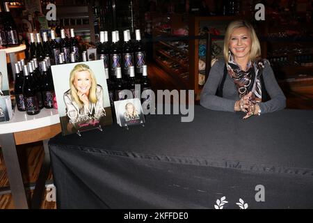 Olivia Newton-John signiert im Promenade Gift Shop, Flamingo Hotel & Casino, Las Vegas, 5.. Dezember 2015 Flaschen mit „Pink & Blue for Two“-Wein und ihre „Summer Nights - Live from Las Vegas“-CD. Stockfoto