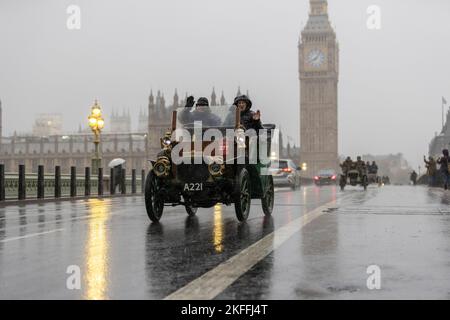 2022 London nach Brighton Veteran Car Run, die weltweit größte Versammlung von Oldtimern, macht sich an einem nassen Wintermorgen über die Westminster Bridge auf den Weg. Stockfoto