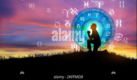 Astrologische Tierkreiszeichen innerhalb des Horoskopkreises. Illustration der Silhouette des Menschen, die die Sonne über dem Tierkreisrad und dem Hintergrund des Sonnenaufgangs berät. Stockfoto