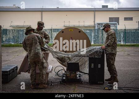 Soldaten der US-Armee, die dem Expeditionssignal-Bataillon 44. zugewiesen wurden, schaffen während der Übung „Heavy Rain III“ auf der Sembach Army Base, Deutschland, 14. September 2022 einen Schutz vor dem Regen. Die Übung bot Service-Mitgliedern die Möglichkeit, Schulungen zu erhalten und in einer Umgebung zu arbeiten, die einer mit begrenztem Zeit-, Personal- und Ressourcenaufwand ähnelt. Stockfoto