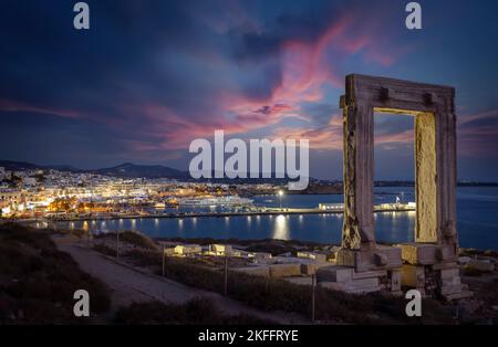Das berühmte Portara-Marmortor vor der beleuchteten Stadt Naxos Stockfoto